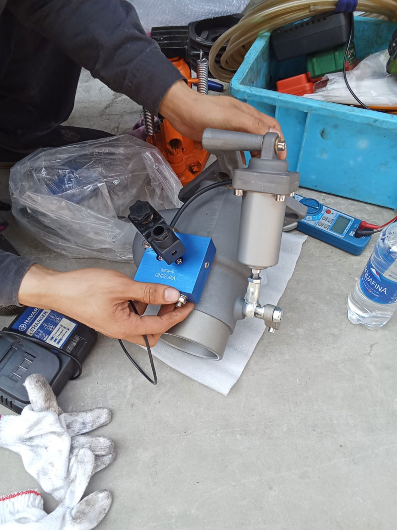Kỹ thuật viên đang điều chỉnh và kiểm tra các thiết bị của máy nén khí Hitachi tại công ty may ở Hải Dương.